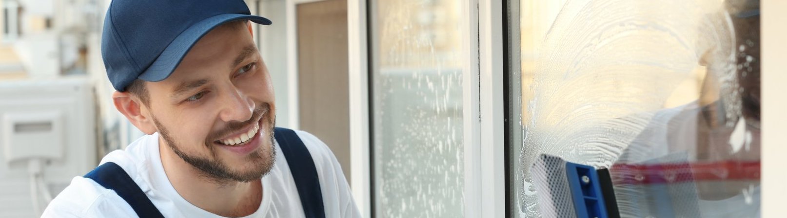 Fortbildung Reinigung und mobiler Dienstleistungsbereich Teilnehmender der Fortbildung Reinigung und mobiler Dienstleistungsbereich bei der Gebäudereinigung. Ein junger Mann reinigt draußen ein Fenster und trägt einen Blaumann.