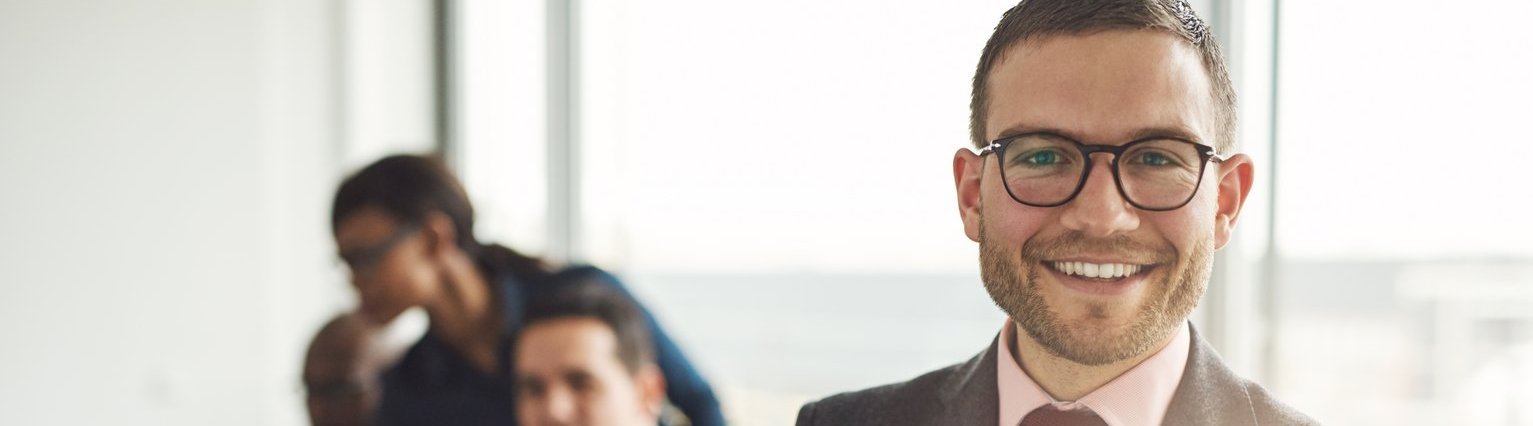 Kaufmännisches Recht für Buchhalter Mehrere Buchhalter studieren Unterlagen zum kaufmännischen Recht. Tutor schaut freudig in Kamera.