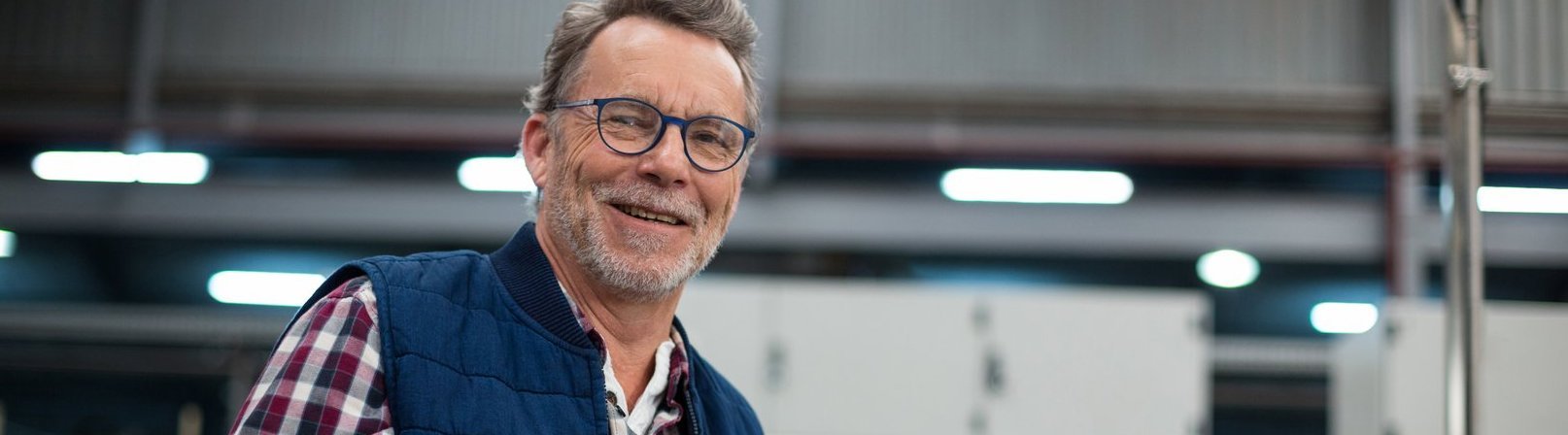 Fortbildung Hausmeister und mobiler Versorgungsbereich :: Detmold Älterer Mann mit Brille und grauem Bart schaut freundlich in die Kamera – Teilnehmer der Fortbildung 'Hausmeister und mobiler Versorgungsbereich' zur Gebäudetechnik und Versorgung.